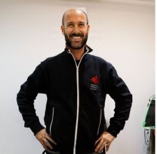 Ritratto di Nicola Polon, proprietario di Serenissima Impianti, in giacca da lavoro nera con logo aziendale, sorridente a lavoro.