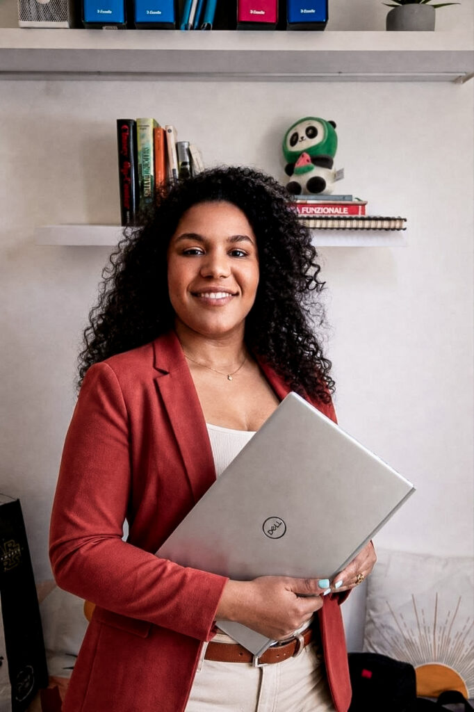 Natalia Canaletti, web e graphic designer, in ritratto professionale con laptop in mano nello studio di lavoro